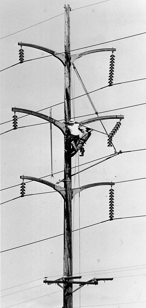 Dan Bryson, left, and Pat Karl replaced an insulator for a 161,000-volt on a 100-foot pole near South Drive and Oakland Gravel Road
